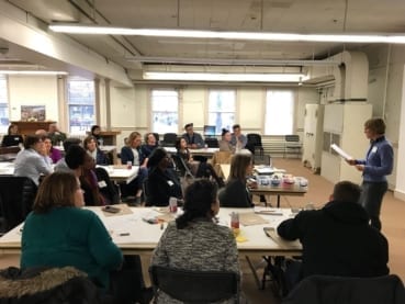 a group of people sitting in a conference room listening to a speaker