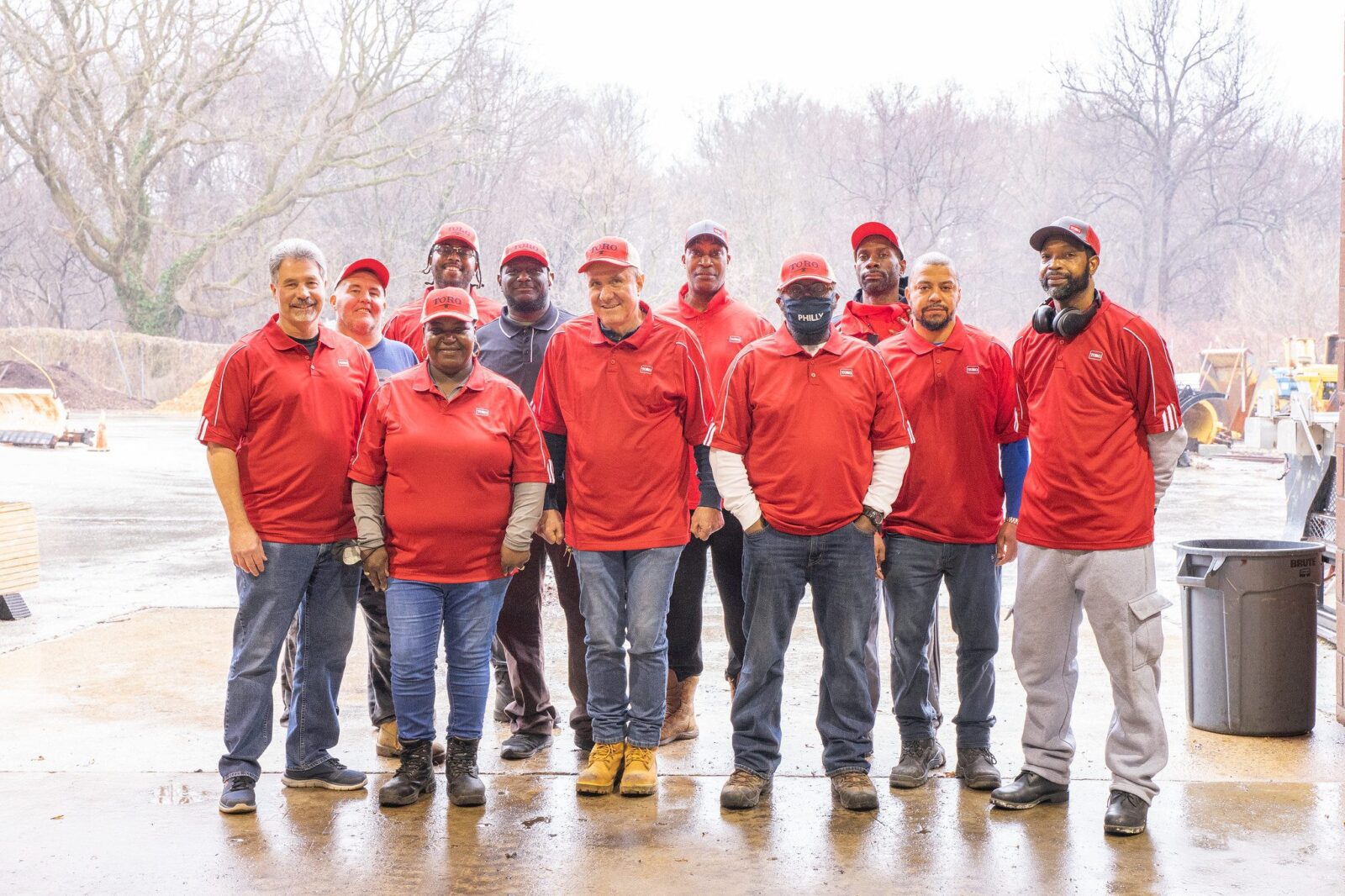 A group of staff in red shirts posing at a recycling center