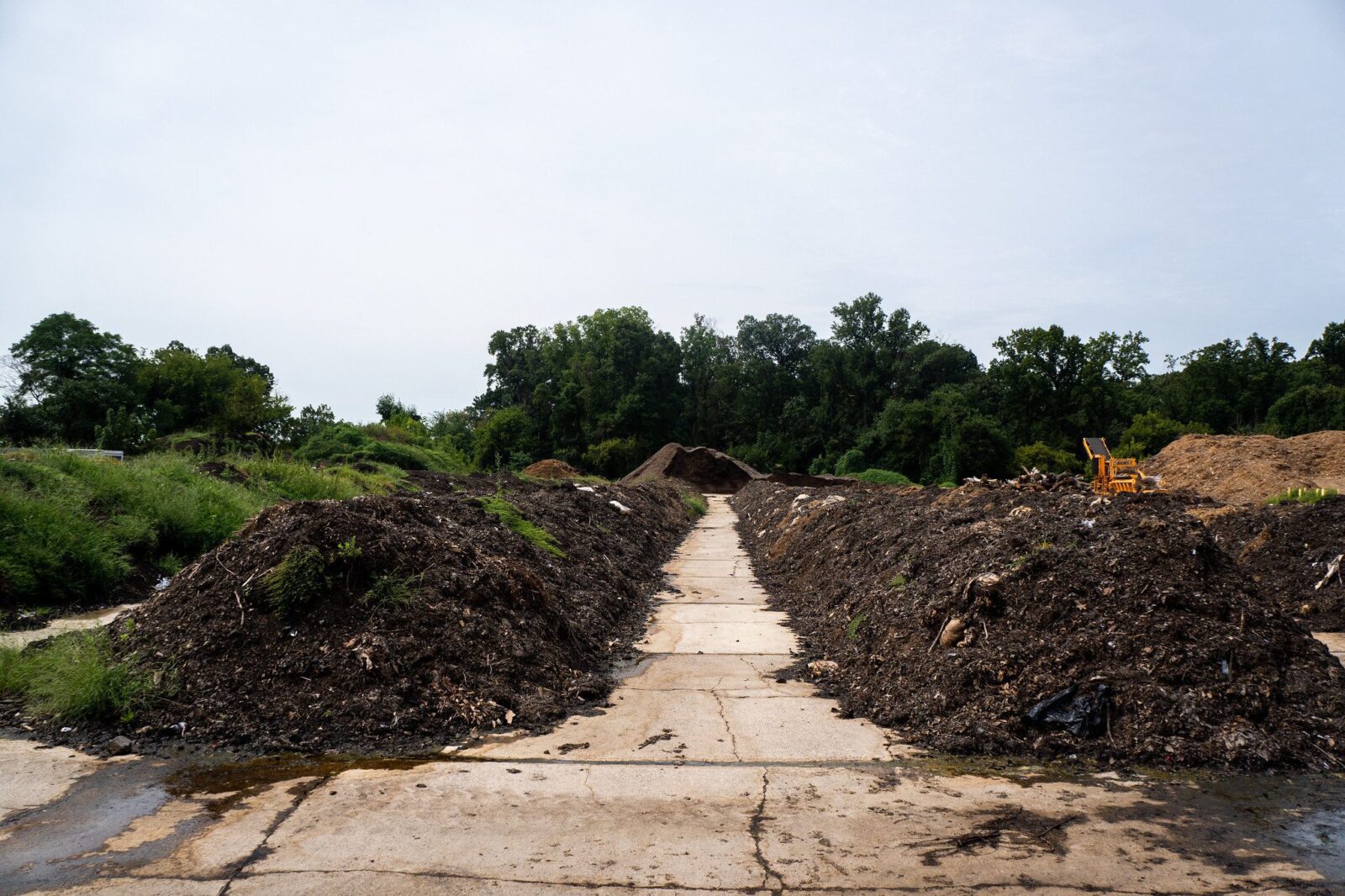 A long outdoor pathway lined with large mounds of dirt
