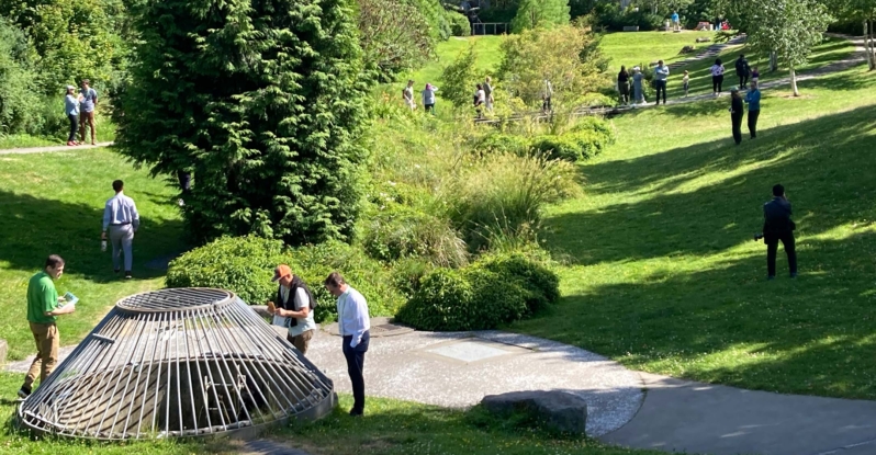 Individuals walking around a park and looking at green water infrastructure