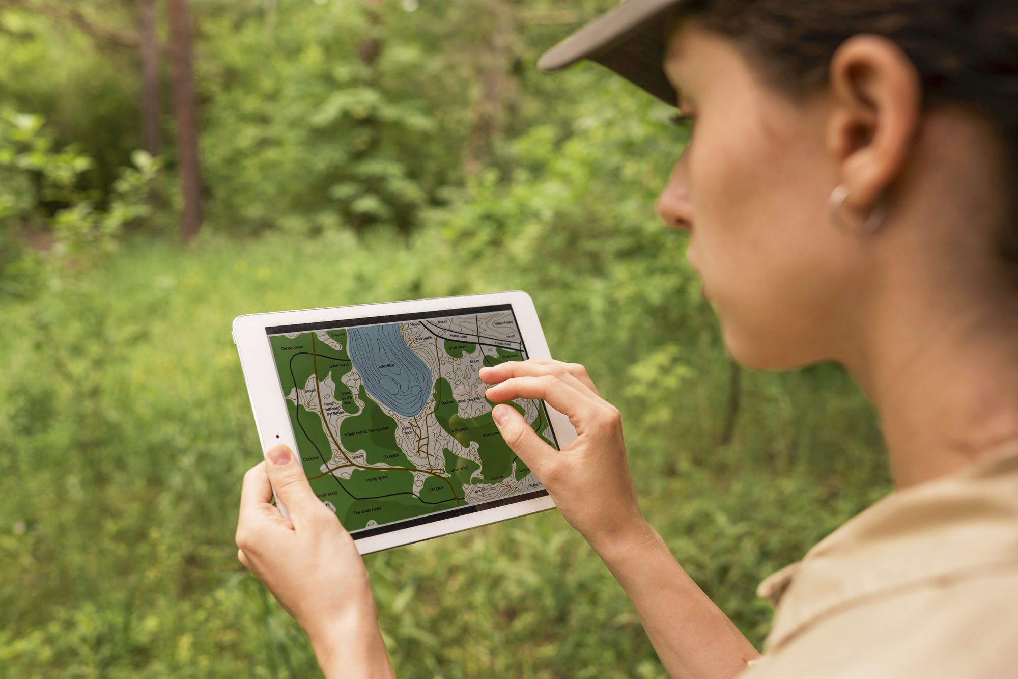 A woman holding an iPad showing topographic map of a park