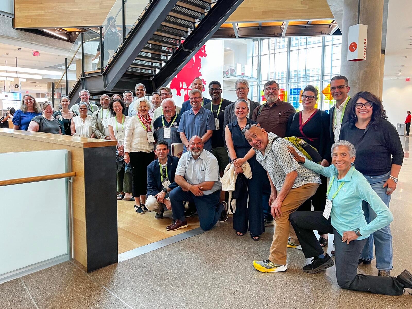 A large group posing in a library hall