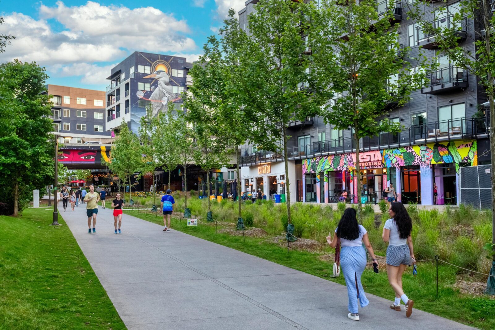 Pedestrians walking and running on a pathway surrounded by urban buildings