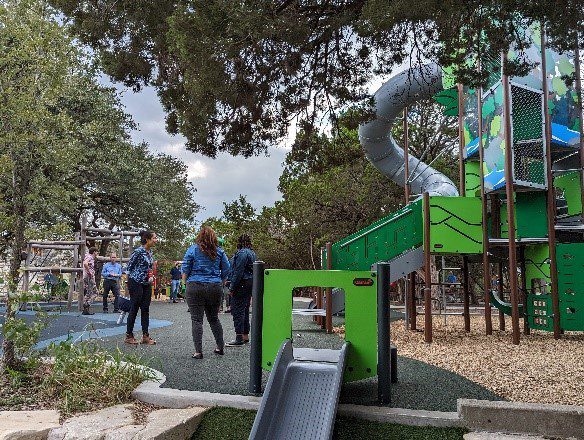 An image of three women standing in a playground.