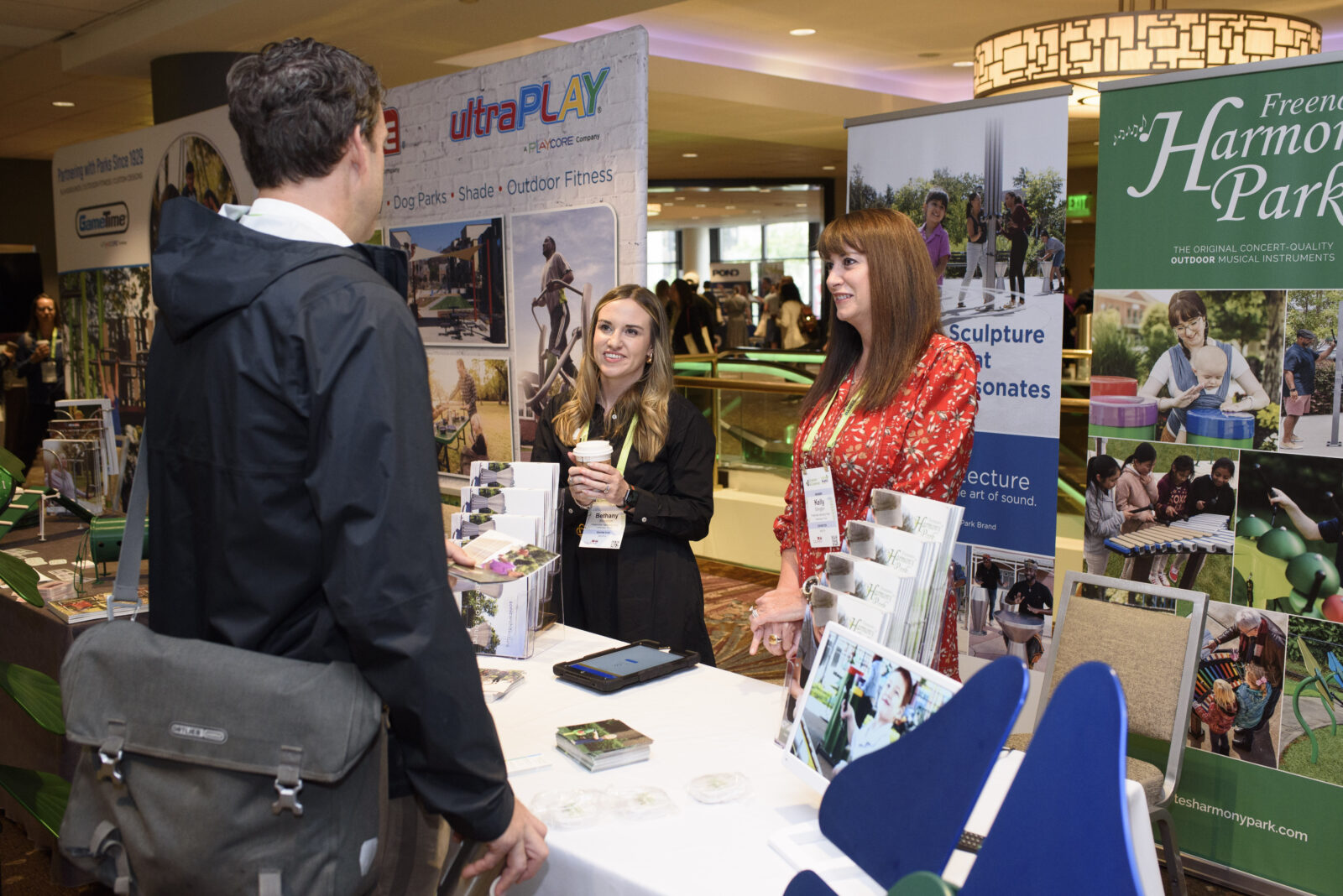 Two exhibitors speaking to an attendee at Greater & Greener Seattle