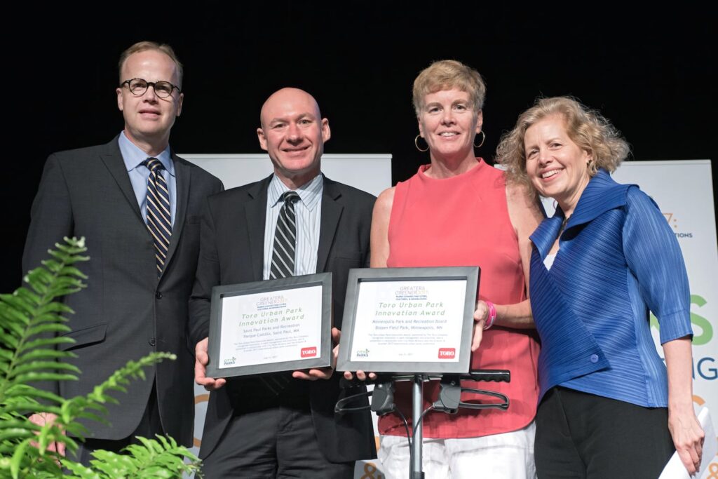 July 2017, Toro CEO Rick Olsen and Executive Director of City Parks Alliance Catherine Nagel present the Toro Company Urban Park Innovation Award to Michael Hahm, Director, Saint Paul Parks and Recreation, and Jayne Miller, Superintendent, Minneapolis Park and Recreation Board.