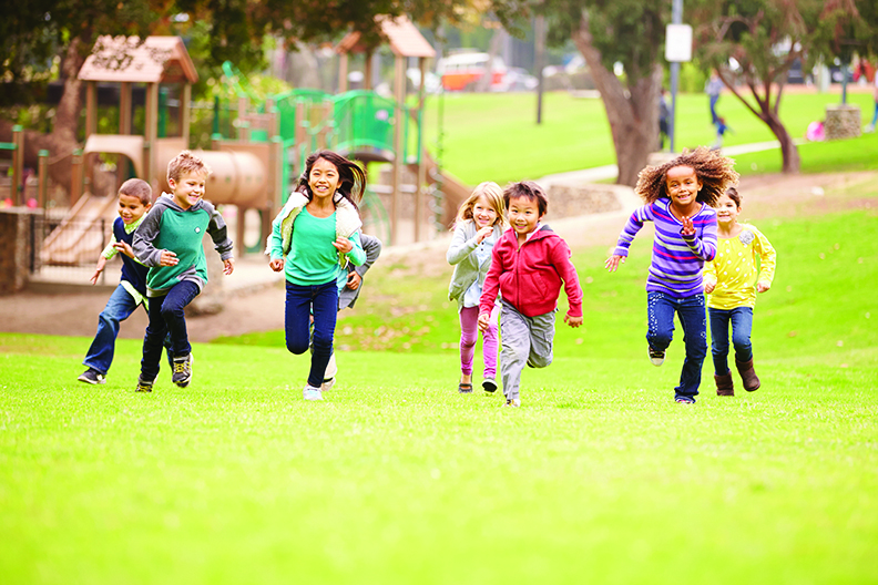 Group Of Young Children Running Towards Camera In Park