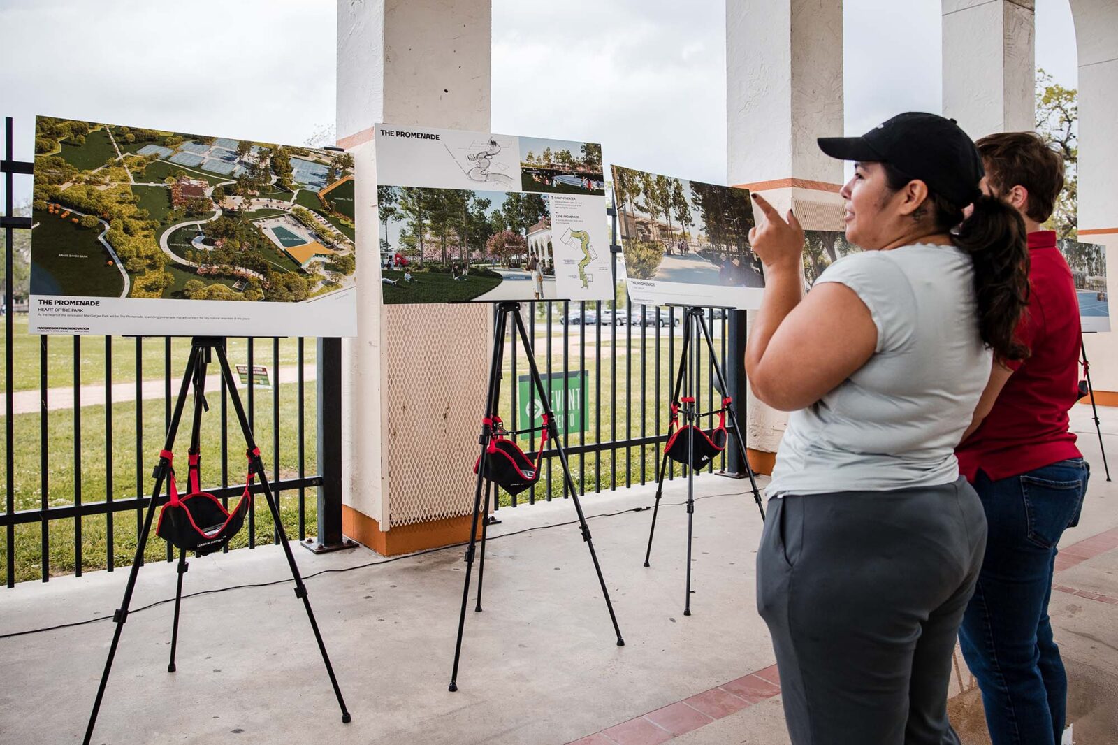 Two women looking onto posters of renderings of a new park