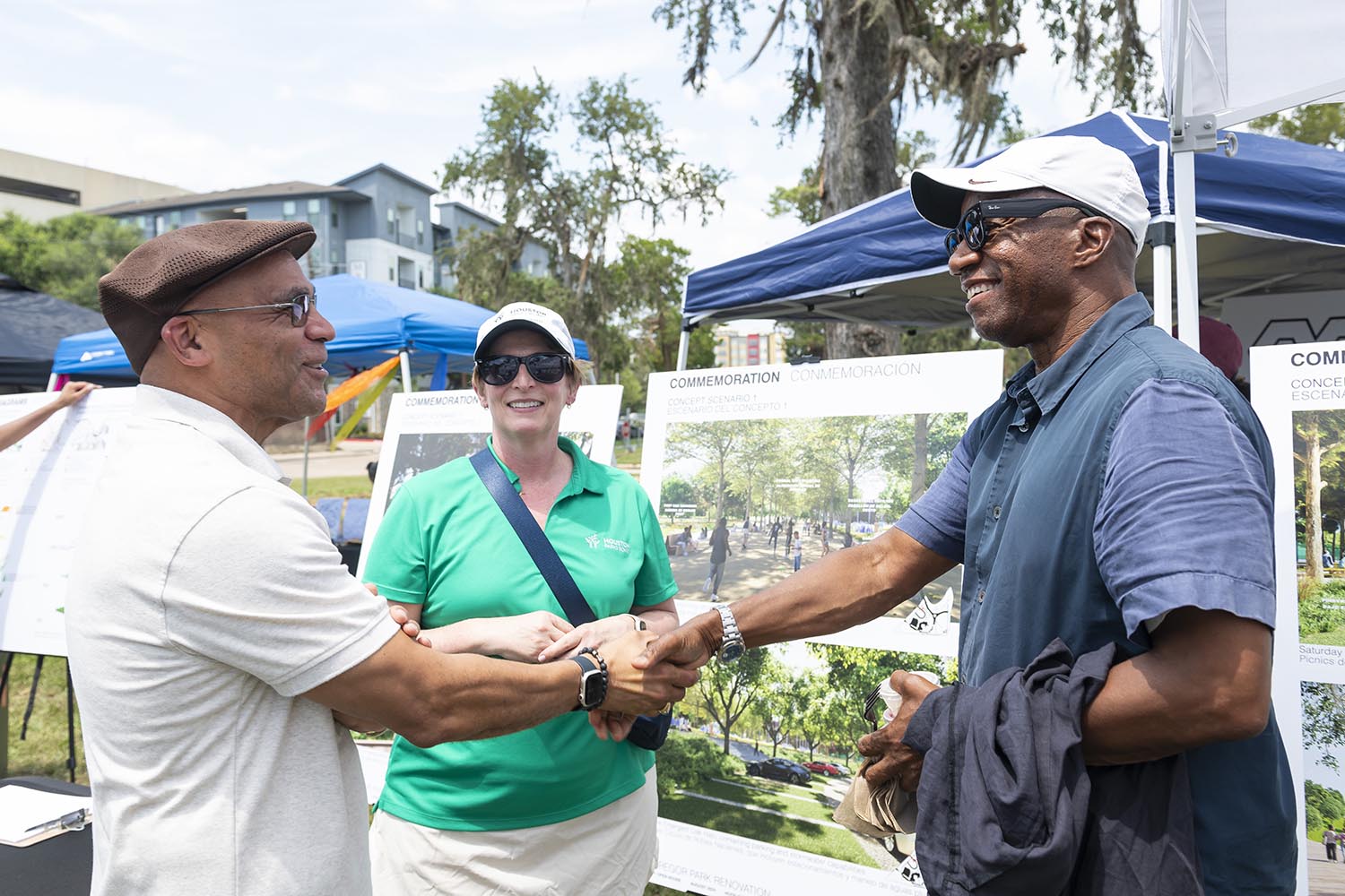 Two men shaking hands and a woman watching