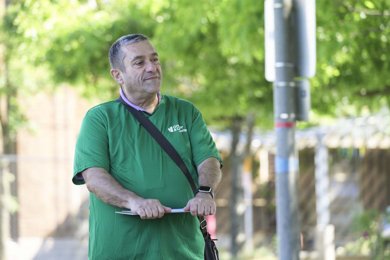A man in a park holding a clipboard