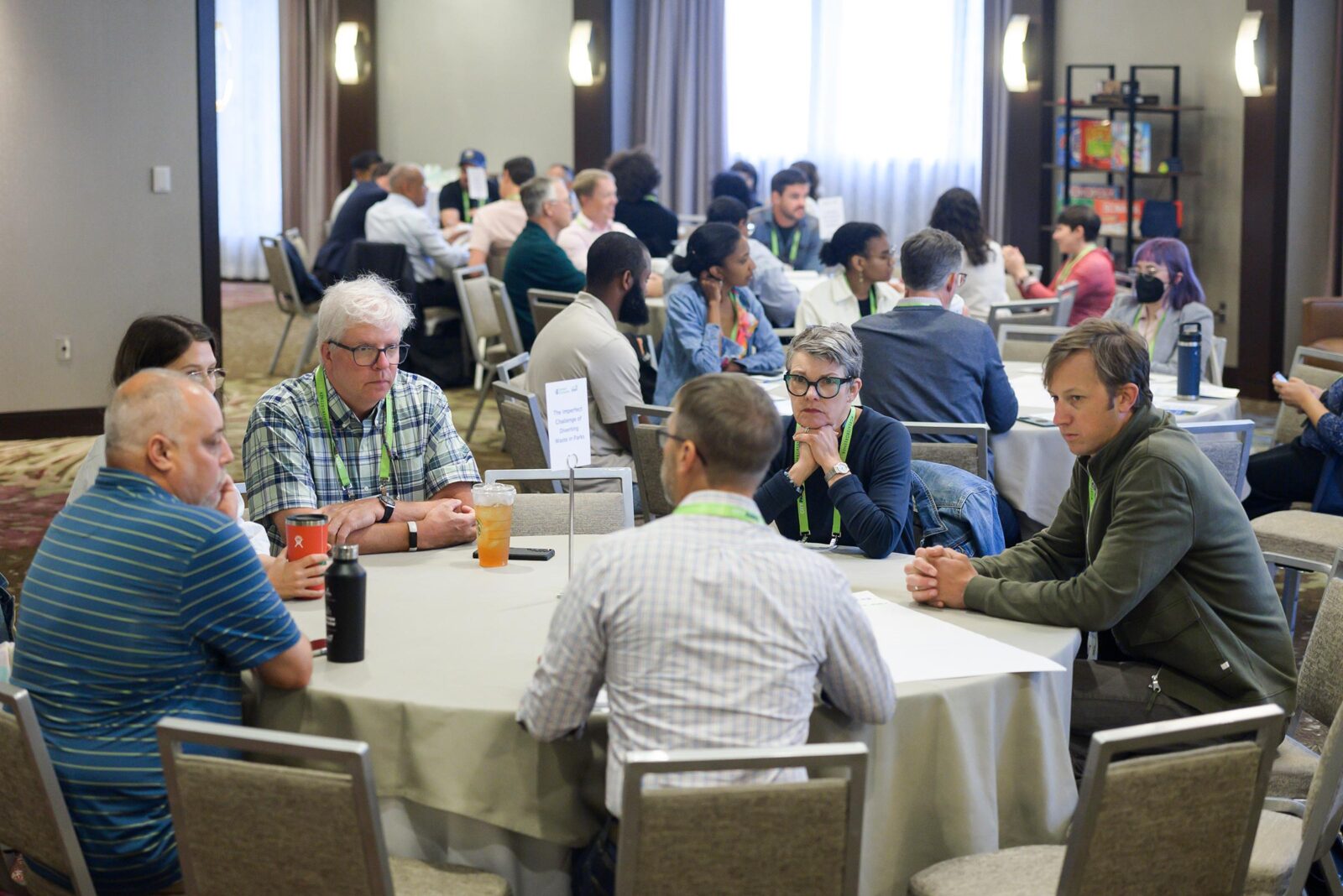 Conference attendees at circular tables in conversation