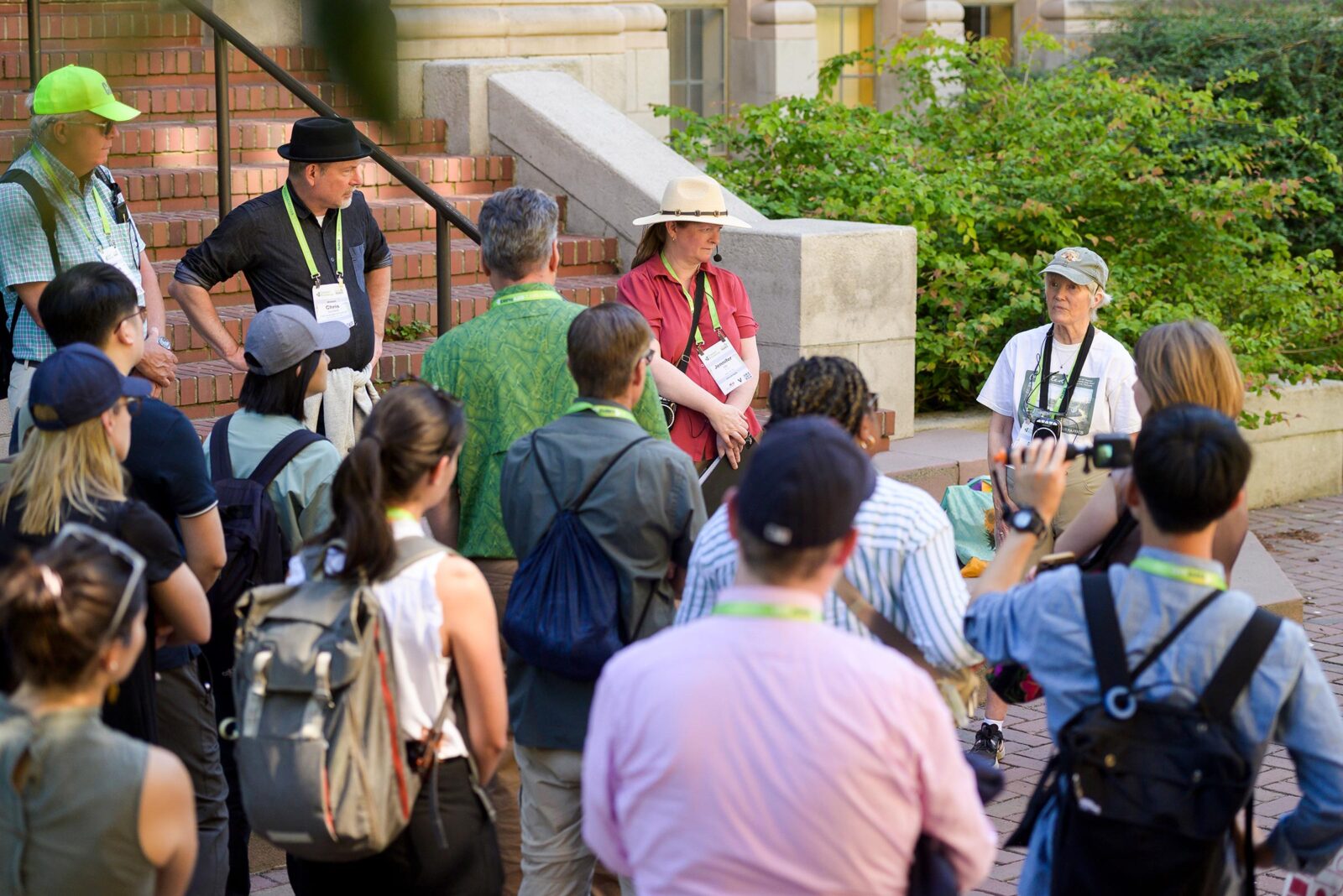 A group of conference attendees listening to a female tour guide in a university park