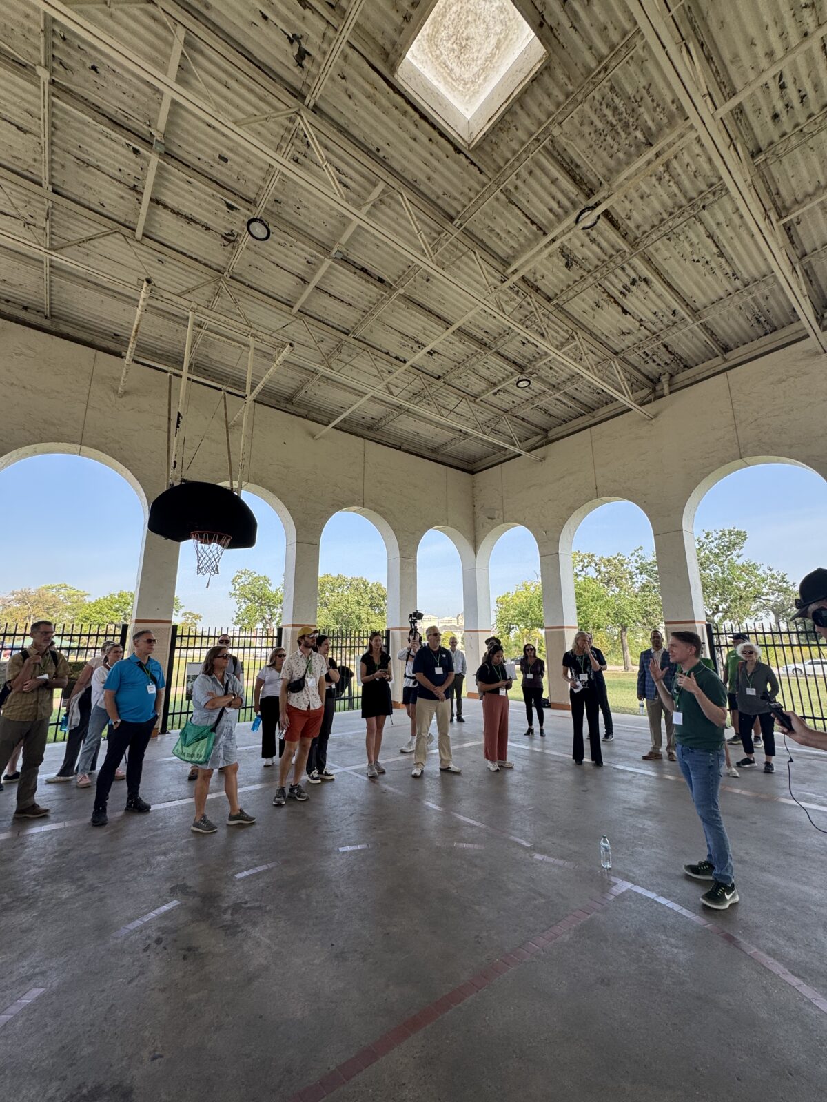A tour group listening to a guide under a covered space