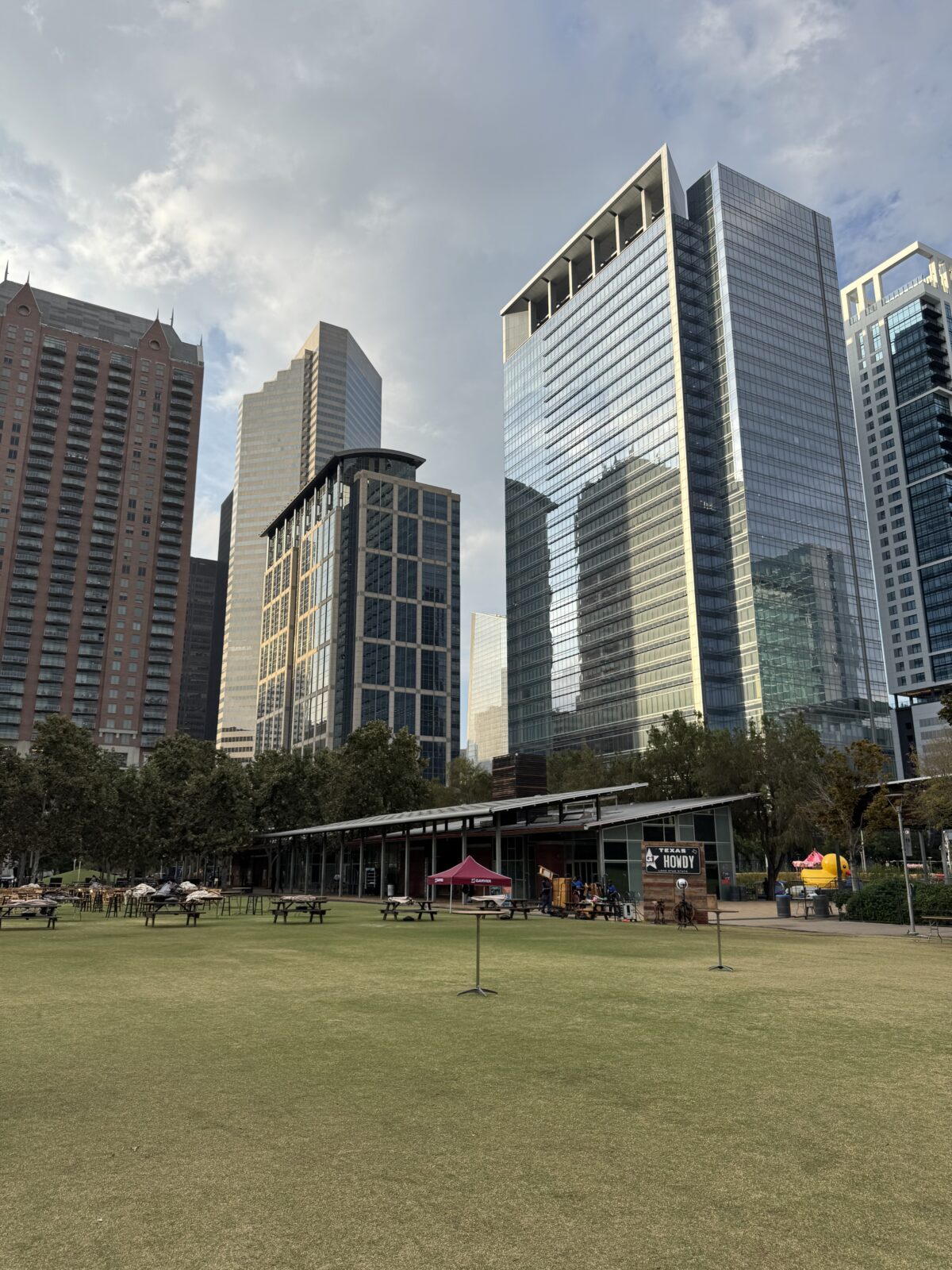 A large grass area in front of city buildings