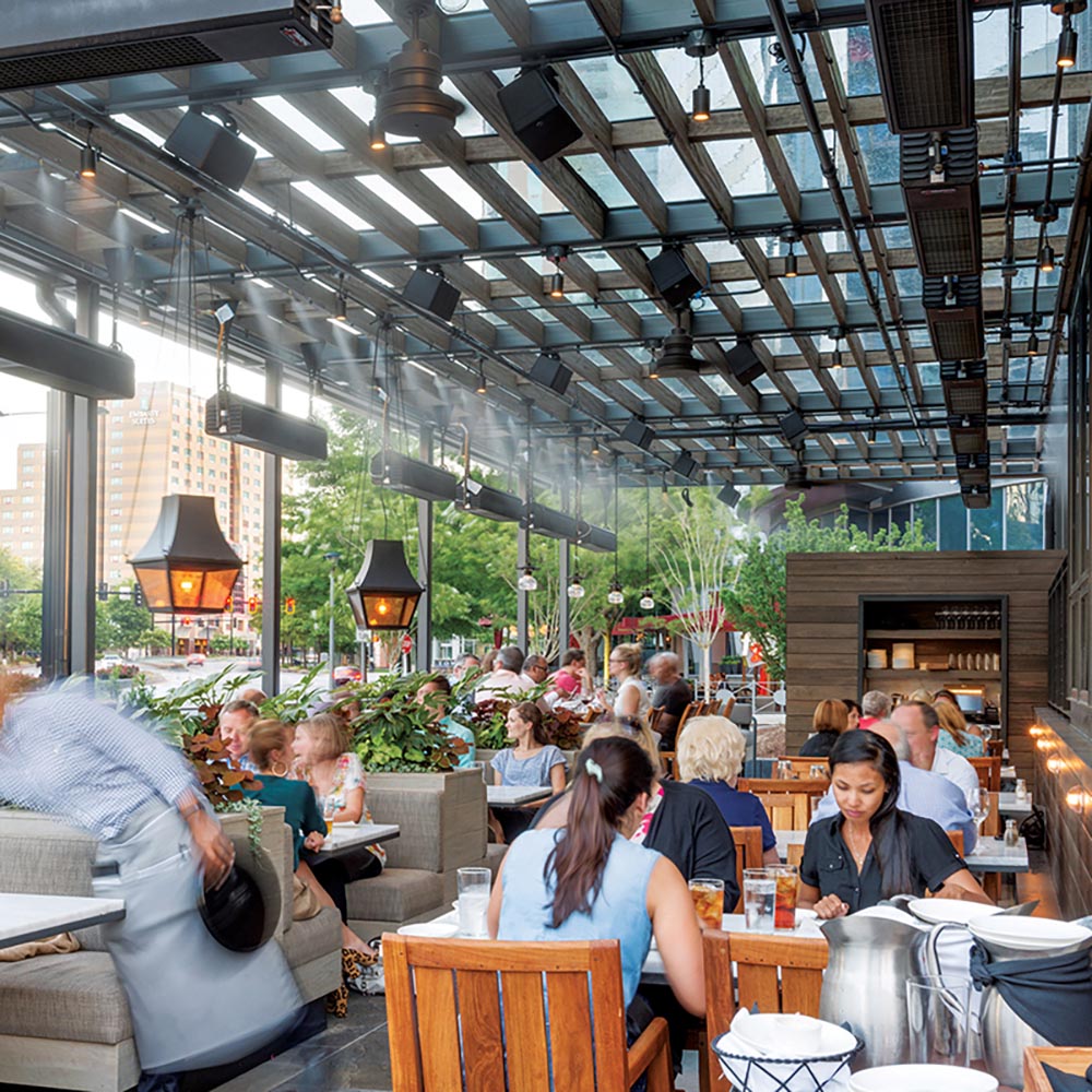 Diners sitting outside under an outdoor restaurant pavilion
