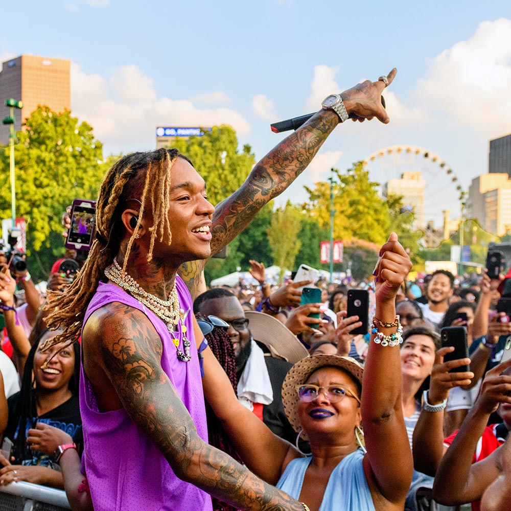 A rapper performing close to a large crowd in Atlanta