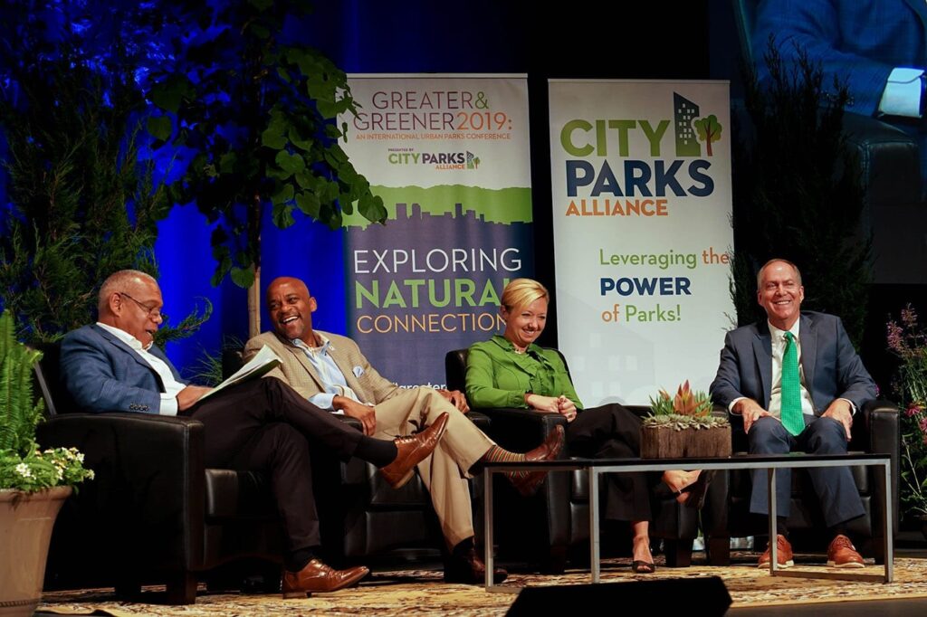 Four people sitting and smiling at a panel