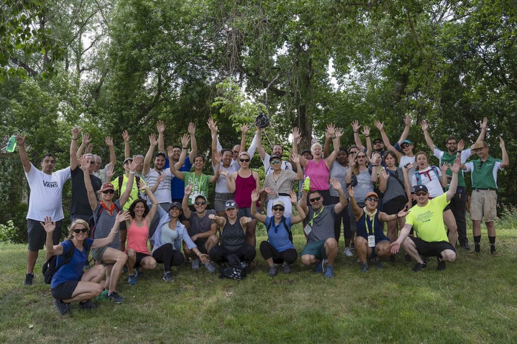 A large group happily posing in a park