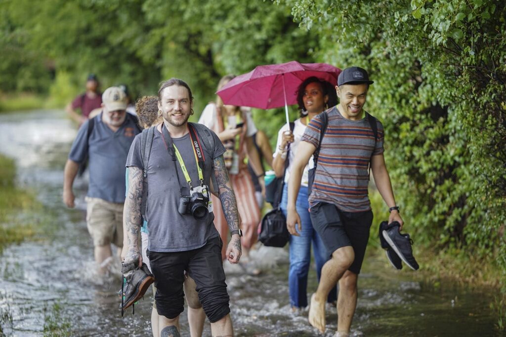 A group of people happily walking through flooded waters