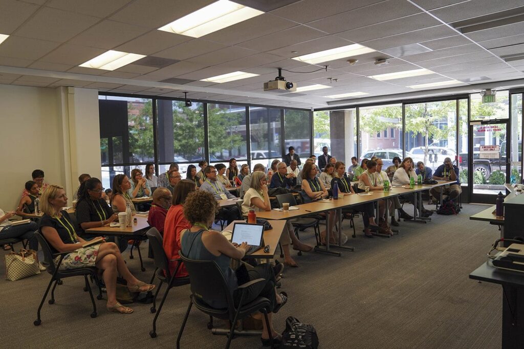 A group of people looking on at a presentation in a classroom