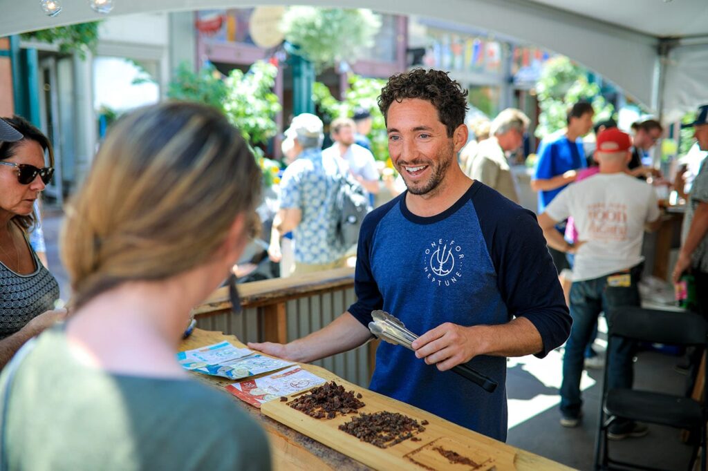 A man serving food at an outdoor tent