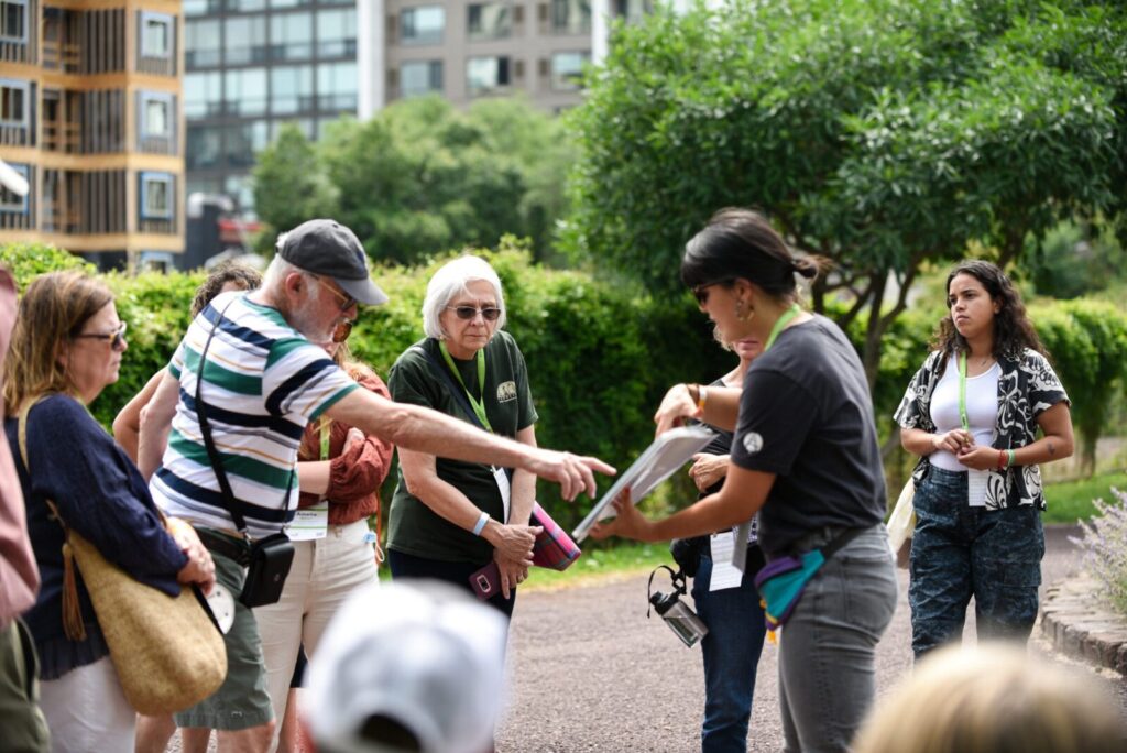 A tour group looking onto a guides paper