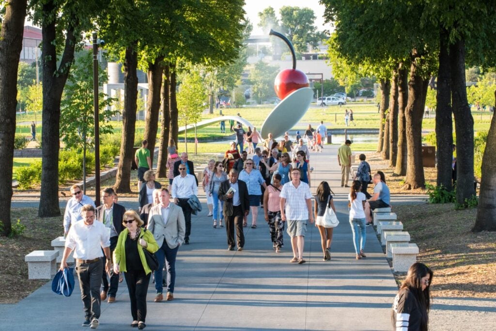 A group walking along a tree-lined walkway