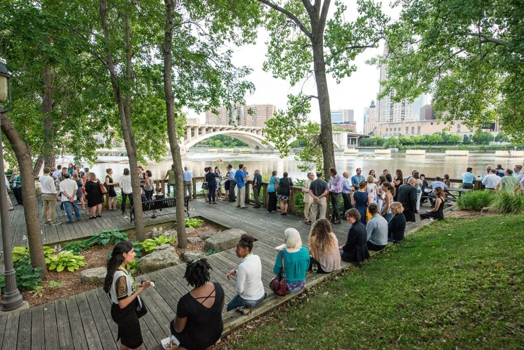 A large group mingling in an outdoor park plaza