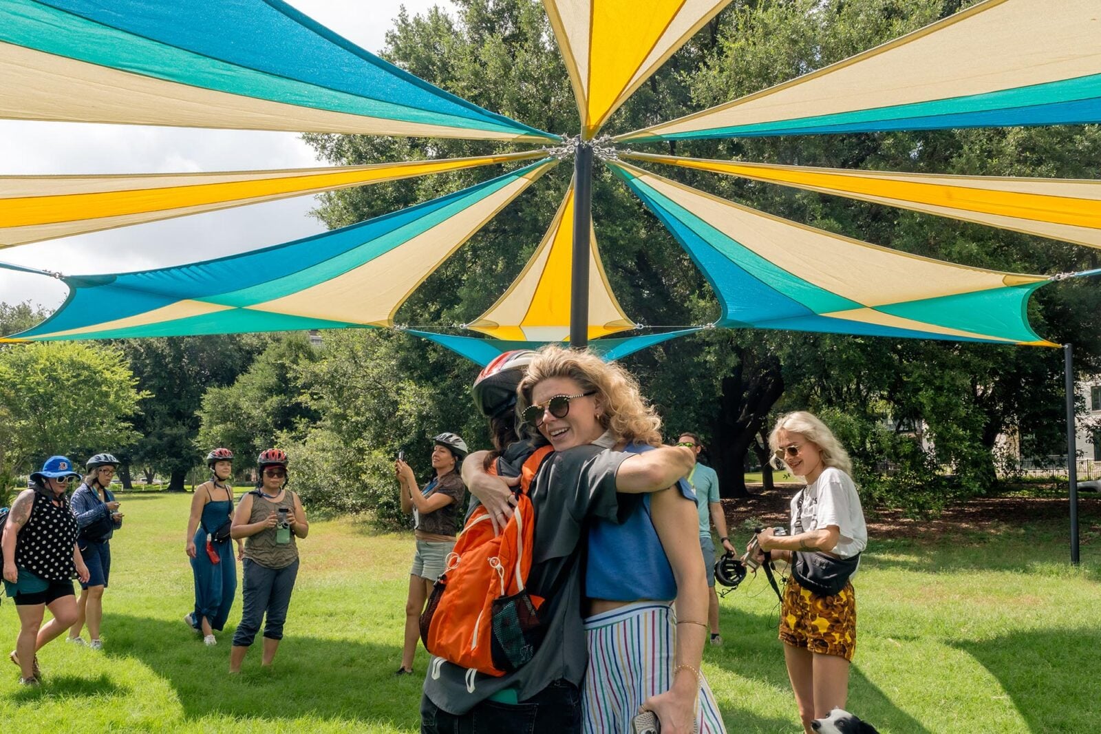 Two women hugging in front of a parachute