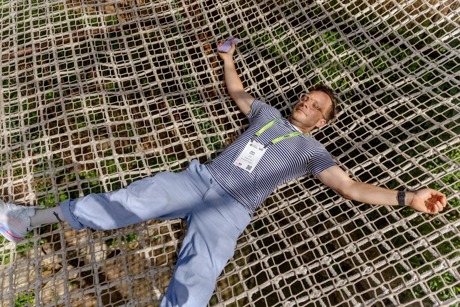 A man laying down on a rope trampoline
