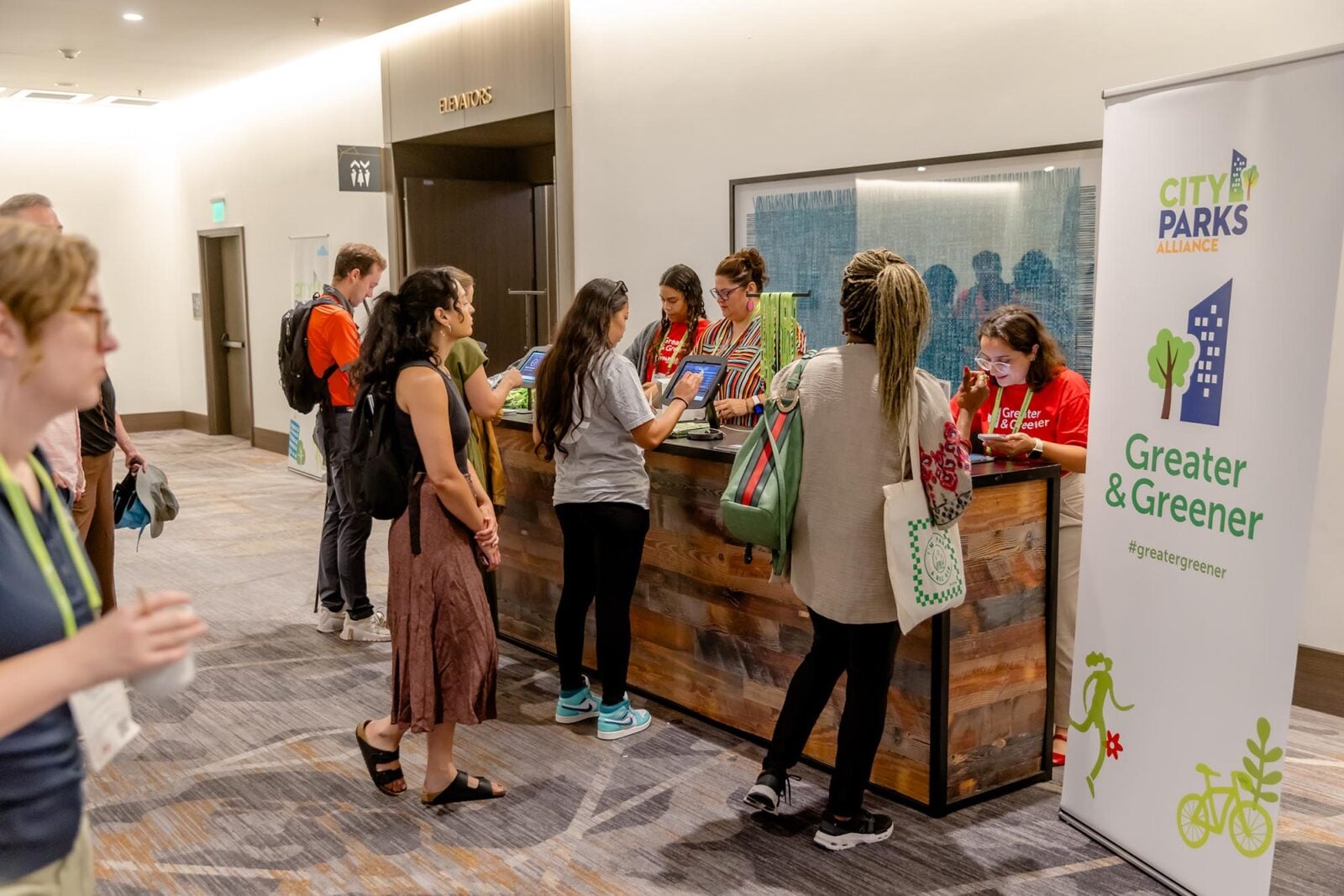 Greater & Greener conference attendees interacting at the registration desk
