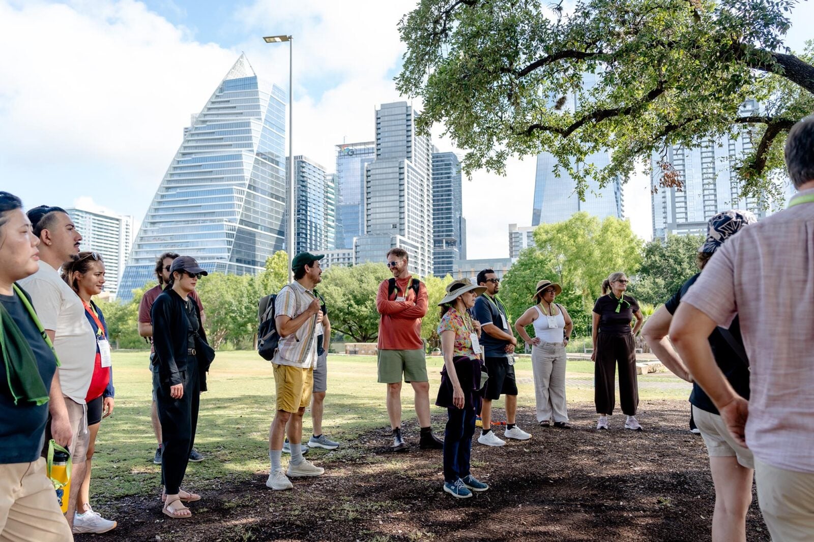 A group of people in an Austin park in front of the skyline