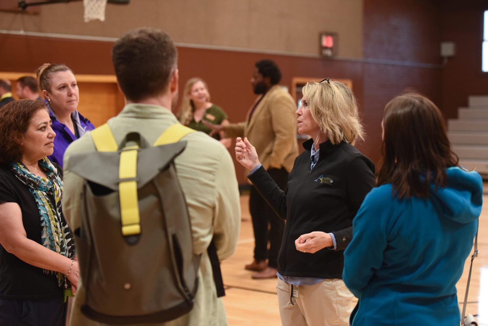 Park Study Tour attendees on a basketball court listening to a tour leader