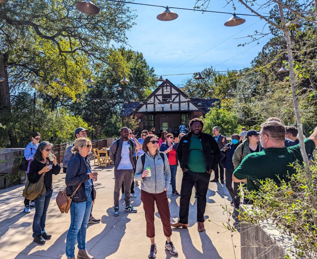 Park Study Tour attendees listening to a tour leader in a park plaza