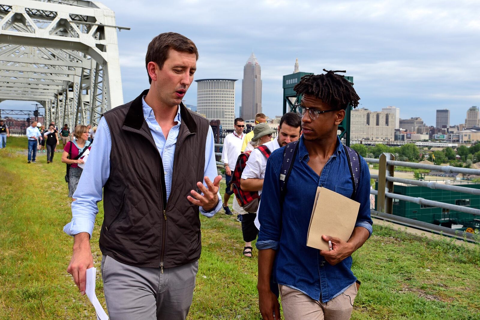 Park Study Tour attendees walking across a grassy walking bridge in Cleveland