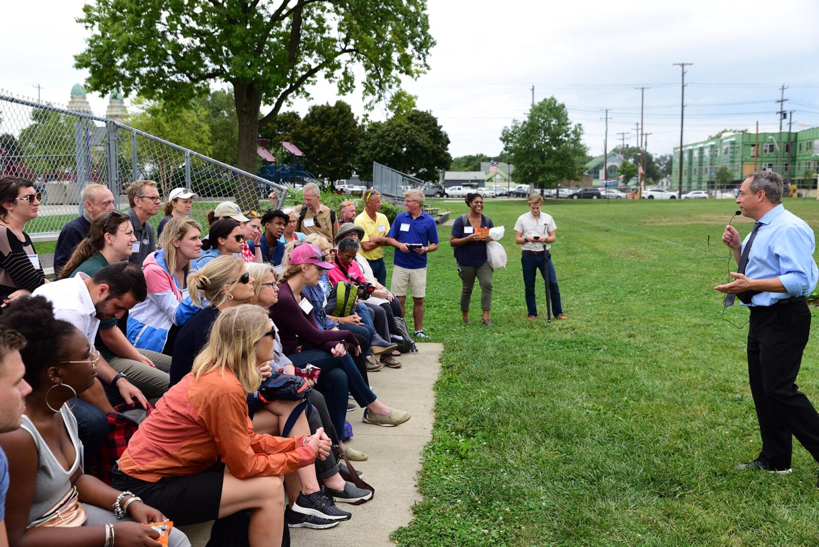 Park Study Tour attendees listening to a tour leader in a park