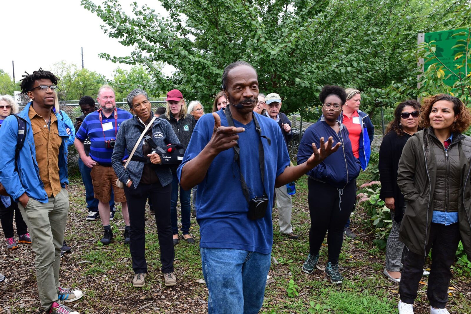 Park Study Tour attendees listening to a tour leader in an orchard