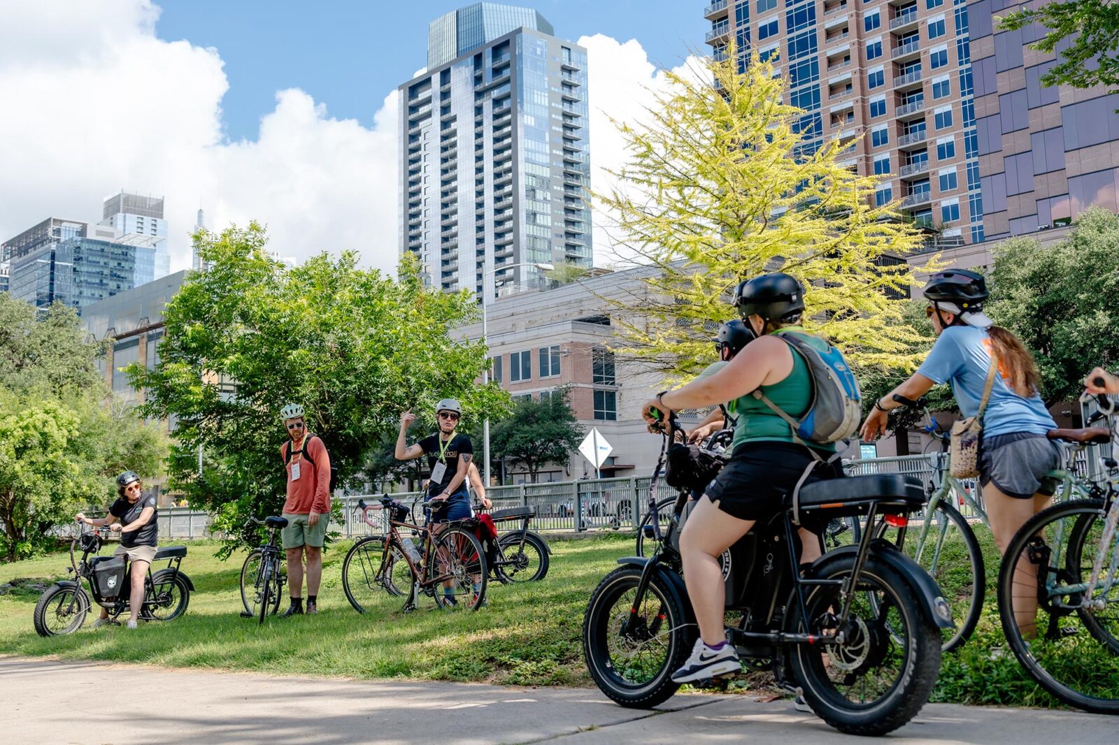 Bike riders surrounding a tour leader in a city park