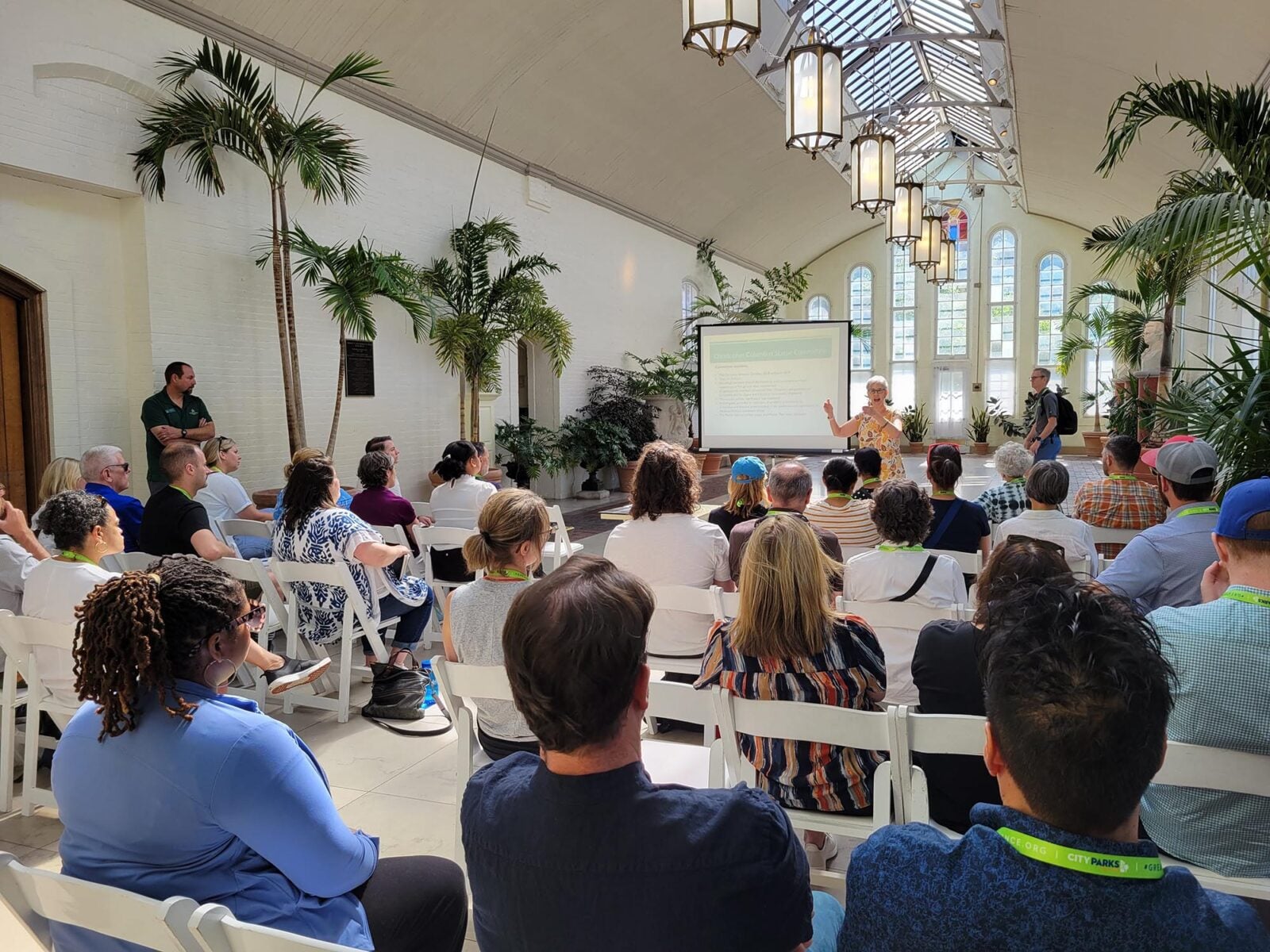 Park Study Tour attendees listening to a presentation in an atrium
