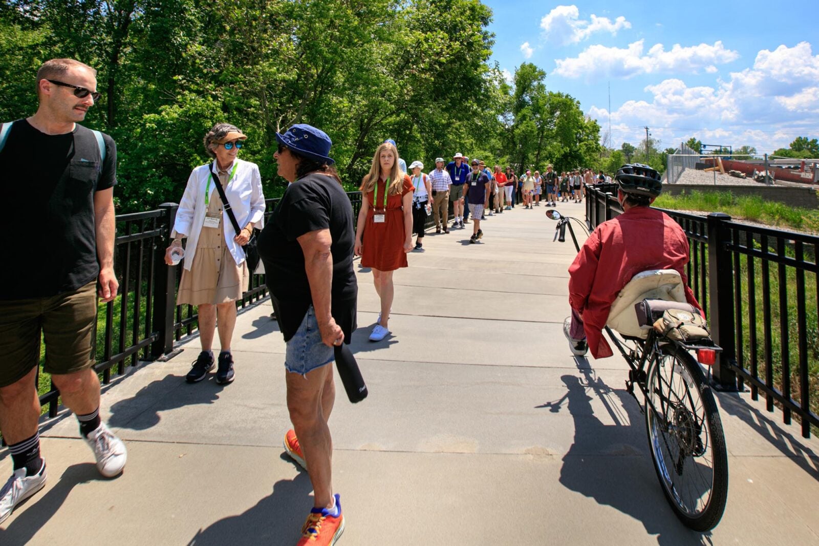 Park Study Tour attendees walking on a pedestrian bridge in a park