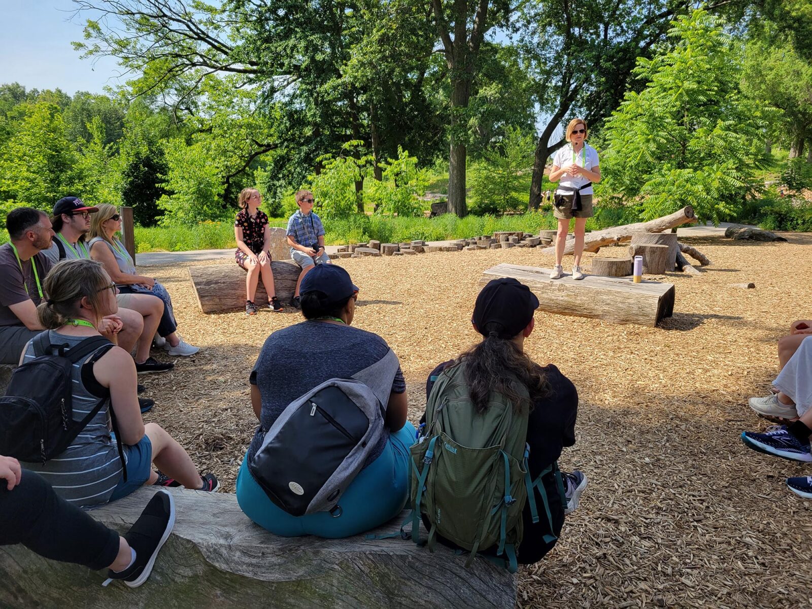Park Study Tour attendees listening to a tour leader in a natural playground